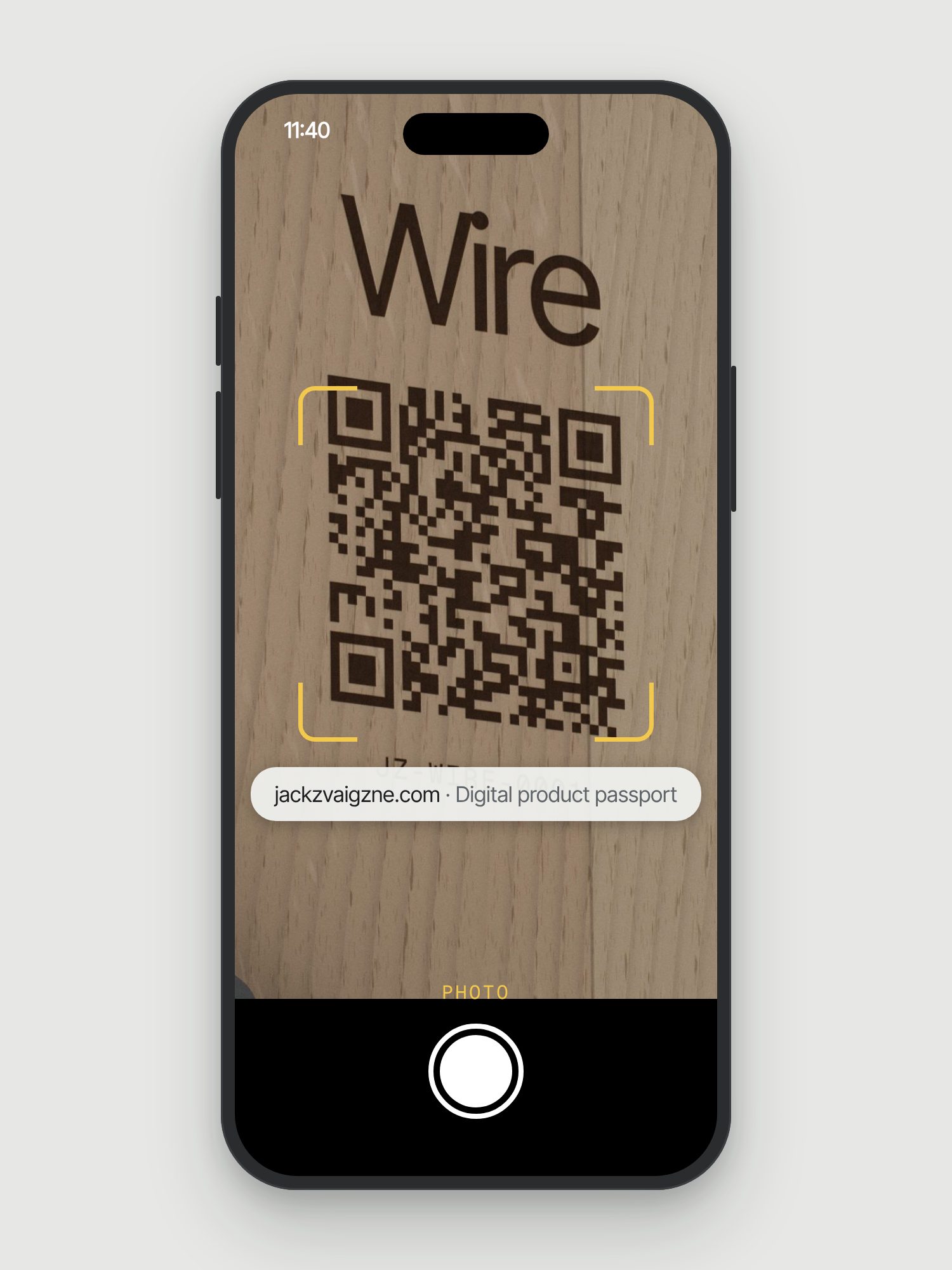 Mockup: a phone camera pointed at the etched QR code under the shelf, with a prompt to open jackzvaigzne.com, the digital product passport